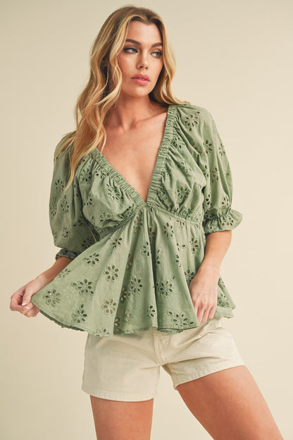 This charming top features delicate eyelet embroidery, feminine ruffles, and a flattering cinched waist.